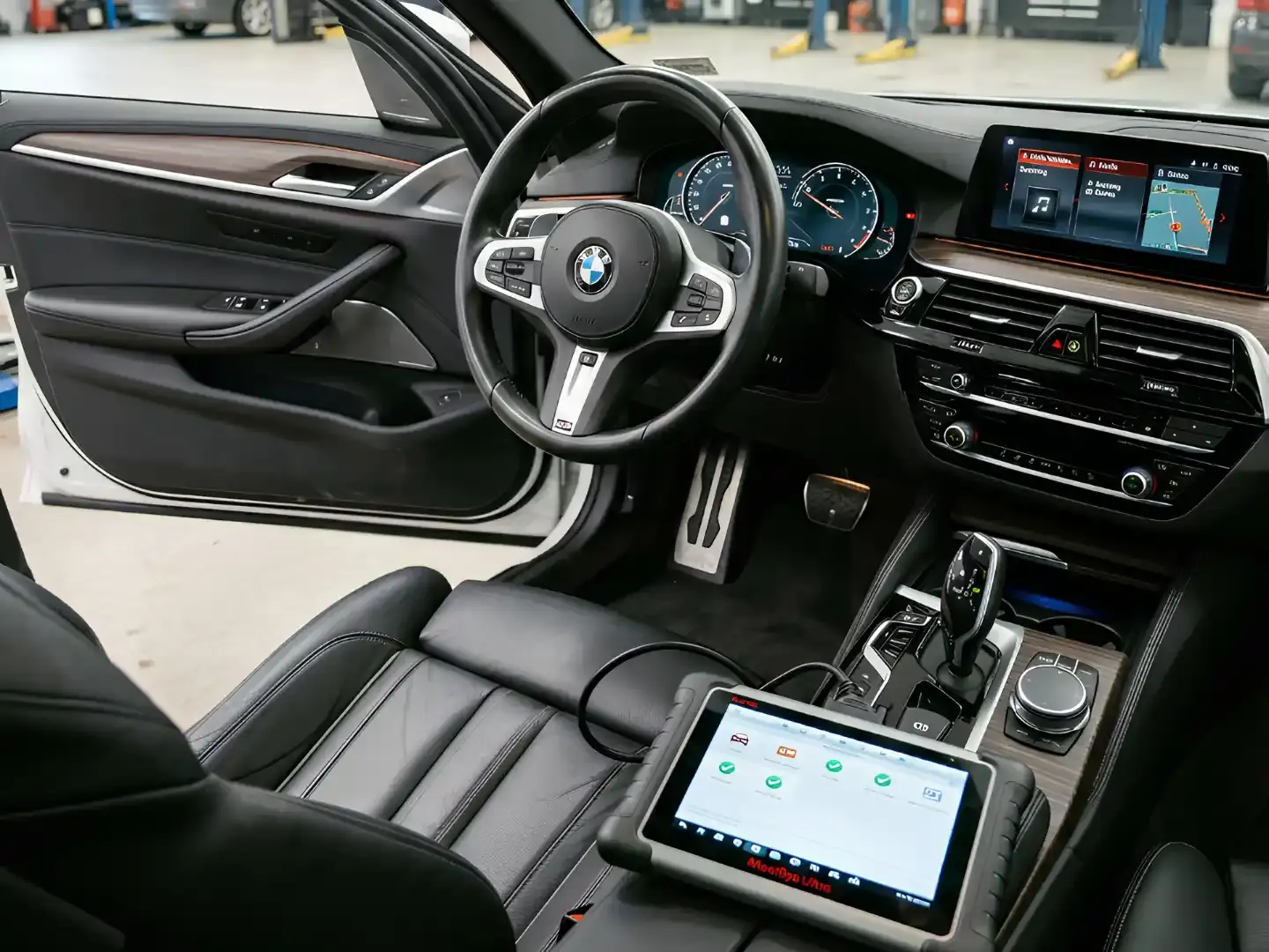 Diagnostic tablet inside a BMW cabin during a pre-purchase scan